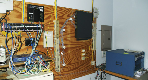 Communications hub—BEFORE reorganization. Photo of a disorganized and deteriorating communications hub.